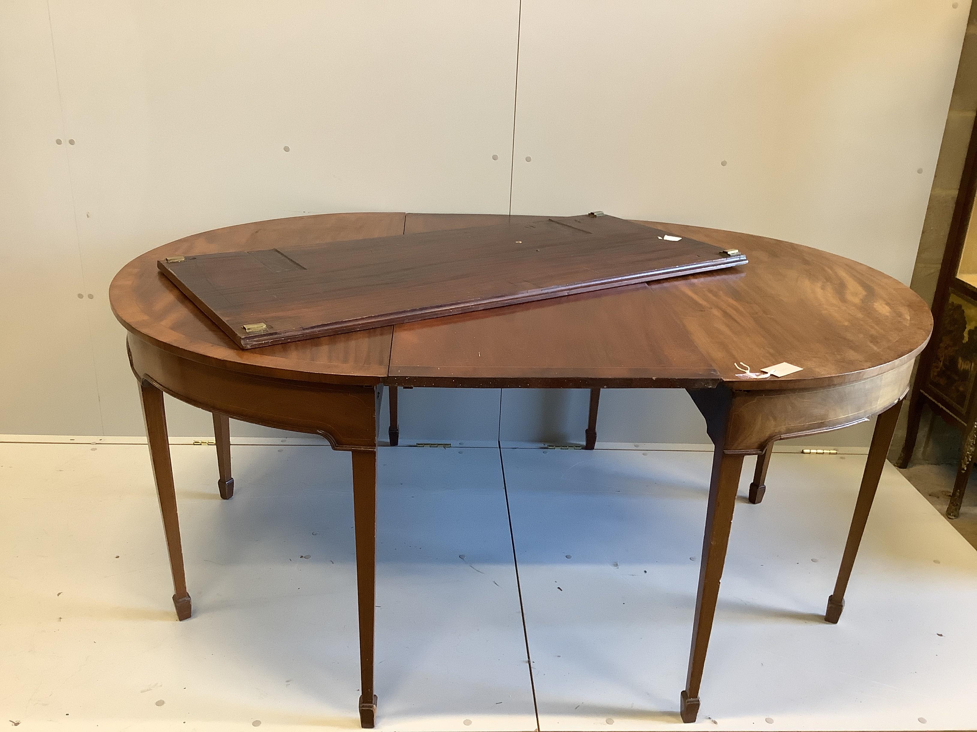 A George III mahogany D-end extending dining table with two leaves